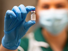 A nurse holds a vial of the Pfizer/BioNTech COVID-19 vaccine at University Hospital, on the first day of the largest immunization program in British history, in Coventry, Dec. 8, 2020.