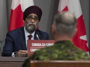 Chief of Defence Staff Jonathan Vance, right, looks on as National Defence Minister Harjit Sajjan makes his opening remarks at a news conference in Ottawa, Friday, June 26, 2020.