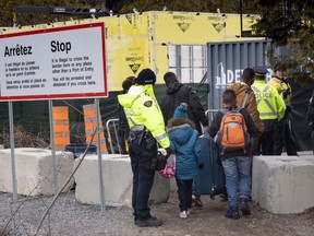 A family, claiming to be from Columbia, is arrested by RCMP officers as they cross the border into Canada from the United States as asylum seekers, on April 18, 2018. near Champlain, N.Y.