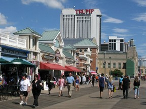 People walk on the boardwalk near the Trump Plaza Casino September 15, 2014 in Atlantic City, New Jersey.