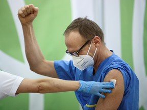 A health care worker reacts after receiving the Pfizer-BioNTech COVID-19 vaccine as the country begins vaccinations against coronavirus disease, at the Hospital Favoriten in Vienna, Austria December 27, 2020.