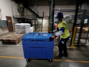 A man pushes a box containing the Pfizer-BioNTech COVID-19 vaccine prepared to be shipped at the Pfizer Global Supply Kalamazoo manufacturing plant in Portage, Michigan, U.S., December 13, 2020.