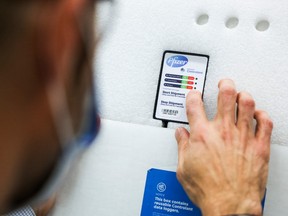 An employee checks the temperature monitor on the shipment of Pfzier-NioNTech vaccine on Dec. 15, 2020.