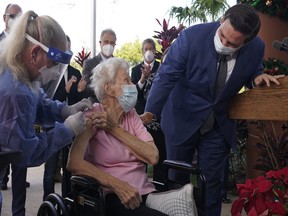 Florida Gov. Ron DeSantis asks Vera Leip, 88, how she feels after nurse Christine Philips, left, administered the Pfizer vaccine at John Knox Village, Wednesday, Dec. 16, 2020.