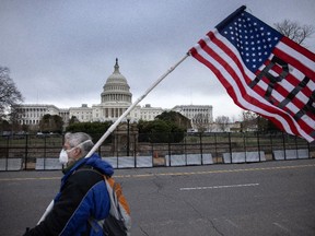 A protester walks by as the American flag flies at half-staff at the U.S. Capitol on January 08, 2021 in Washington, DC.
