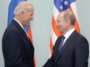 Russian Prime Minister Vladimir Putin, right, shakes hands with then-U.S. vice-president Joe Biden in 2011.
