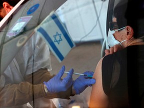 An Israeli senior citizen receives her second Pfizer COVID-19 vaccine at the Maccabi Health Services drive-in vaccination centre, in the northern coastal city of Haifa, on Jan. 11.