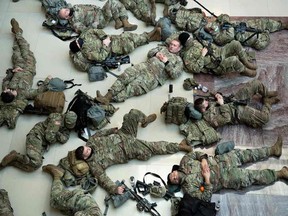 Members of the National Guard rest in the Capitol Visitors Center on Capitol Hill in Washington, DC. A decision to turn a chilly underground parking garage into an overnight billet for National Guard troops in Washington to protect President Joe Biden's inauguration has stirred an uproar.