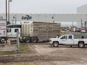 Workers wearing protective masks stand outside the Cargill Inc. beef plant in High River, Alberta, Canada, on Monday, May 4, 2020.