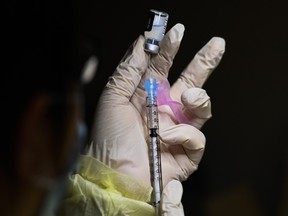 A pharmacist technician fills the syringe with the Pfizer-BioNTech COVID-19 vaccine at a Toronto vaccine clinic.