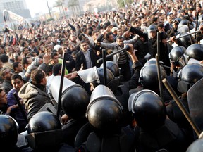 Anti-government protesters demonstrate near riot police in Tahrir Square in downtown Cairo on Jan. 25, 2011.