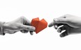 hand passing red paper heart to another hand