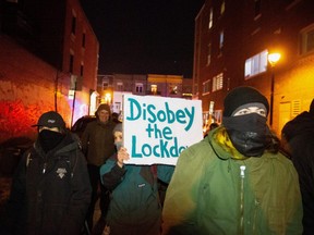 Protesters walk down streets as they ignore a night curfew imposed by the Quebec government to help slow the spread of COVID-19 pandemic in Montreal, Quebec, January 9, 2021.