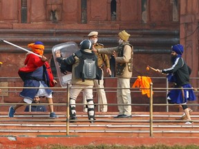 A Nihang (sikh warrior) beats a policeman with a baton during a protest against farm laws introduced by the government, at the historic Red Fort in Delhi, India, January 26, 2021.