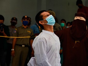 A man accused of having gay sex is publicly caned by a member of the Shariah police in Banda Aceh, Indonesia, on Jan. 28, 2021.