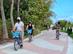 Tourists bike along the beach in Miami, Fla, on Dec. 20, 2020, amid the coronavirus pandemic.