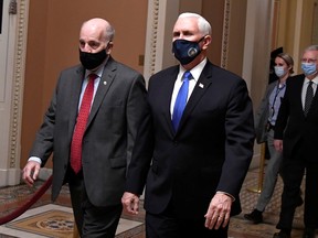 Vice President Mike Pence (R) is escorted by Sgt. at Arms Michael Stenger (L), followed by Senate Majority Leader Mitch McConnell (R-KY) as they walk to the House in the U.S. Capitol to continue a joint session to certify President-elect Joe Biden, in Washington, U.S., January 6, 2021.