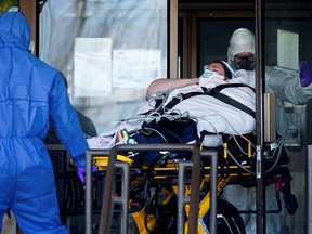 Ambulance attendants transport a resident from Centre d'hebergement Yvon-Brunet, a seniors' long-term care centre in Montreal, on April 18, 2020, amid the outbreak of the coronavirus pandemic.