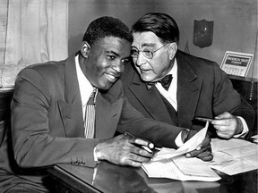 Baseball great Jackie Robinson, left, talks with Brooklyn Dodger owner Branch Rickey during a meeting in New York, on Jan. 25, 1950.