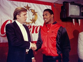 In a photo from March 8, 1984, Donald Trump, then owner of the New Jersey Generals, shakes hands with Herschel Walker in New York after Walker agreed to a four-year contract with the USFL football team.