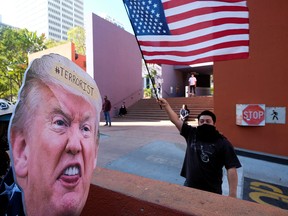 A supporter of President Donald Trump waves a flag in front of anti-Trump protesters during a demonstration in Pershing Square, in downtown Los Angeles, Calif, on Jan. 9, 2021.