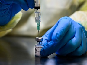 A health-care worker prepares a dose of the Pfizer-BioNTech COVID-19 vaccine at a University Health Network vaccine clinic in Toronto on Jan. 7, 2021.