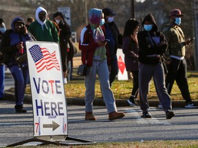 A sign is seen as voters line up to cast a ballot in a U.S. Senate run-off election, at a polling location in Marietta, Ga., on Jan. 5.