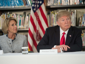 US President Donald Trump and Education Secretary Betsy DeVos listen during a meeting with parents and teachers at Saint Andrew Catholic School in Orlando, Florida, on March 3, 2017.