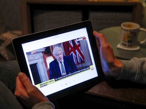 Teacher Wendy Couldridge watches on a device as Britain's Prime Minister Boris Johnson announces a lockdown in England, amid the coronavirus disease (COVID-19) outbreak, in Hertford, Britain, January 4, 2021.