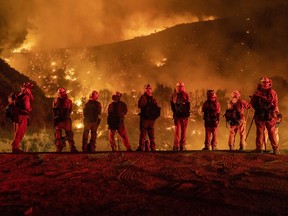 Inmate firefighters watch as the El Dorado Fire burns a hillside near homes in Mountain Home Village, Calif., inside the San Bernardino National Forest on Sept. 9.