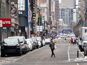A man crosses a quiet Saint-Catherine Street under Quebec's new COVID-19 lockdown in Montreal, on Monday, January 11, 2021.