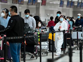 People line up and check in for an international flight at Pearson International airport during the COVID-19 pandemic in Toronto on Wednesday, Oct. 14, 2020.