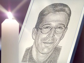 A portrait of the Wall Street Journal's reporter Daniel Pearl stands with a candle at the altar at Fleet Street's journalists chapel St Brides Church prior to a memorial service in London March 5, 2002.