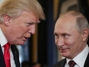 Then-U.S. President Donald Trump, left, chats with Russia's President Vladimir Putin as they attend the APEC Economic Leaders' Meeting on Nov. 11, 2017.