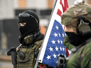 Members of the Boogaloo Boys stand armed in front of the Oregon State Capitol building in Salem at a nationwide protest called by anti-government and far-right groups supporting Donald Trump.