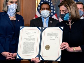 Speaker of the House Nancy Pelosi (D-CA) displays a signed an article of impeachment against President Donald Trump at the U.S. Capitol on January 13, 2021 in Washington, DC.