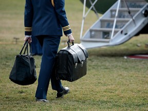 A military aide carries a case with the launch codes for nuclear weapons on to Marine One as President Donald Trump prepares to take off from the White House, January 26, 2017.