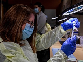 Pharmacy technician supervisor Tamara Booth Rumsey prepares a Pfizer-BioNTech coronavirus disease (COVID-19) vaccine at The Michener Institute, in Toronto on Jan. 4, 2021.