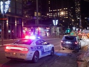 A car is pulled over by a police cruiser in Montreal, Saturday, January 9, 2021, as the COVID-19 pandemic continues in Canada and around the world. The Quebec