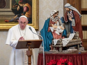 This photo taken on January 10, 2021 and handout on January 11, 2021 by the Vatican Media shows Pope Francis holding a weekly live streamed Angelus prayer by a Nativity Scene, from the library of the apostolic palace in The Vatican, during the COVID-19 pandemic caused by the novel coronavirus.