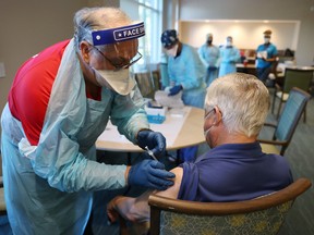 A healthcare worker with American Medical Response, Inc  working with the Florida Department of Health in Broward administers a Pfizer-BioNtech COVID-19 vaccine at the John Knox Village Continuing Care Retirement Community on January 6, 2021 in Pompano Beach, Florida.
