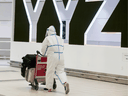 A passenger is covered head to toe at the international arrivals area at Pearson International Airport on January 26, 2021. News that vaccines will not necessarily end the COVID nightmare has the potential to ruin travel plans for the second half of 2021.