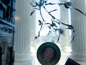 An anti-Biden sticker is seen on a cracked window a day after a pro-Trump mob broke into the US Capitol, Jan. 7, 2021, in Washington, DC.