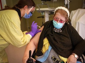 Judy McKnight receives the first dose of the COVID-19 vaccine from registered nurse Julie Denouden at the Canmore General Hospital on Jan. 6. McKnight was the hospital’s first long-term care resident to receive the vaccine.