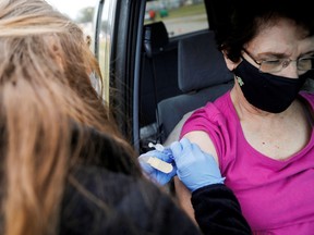 medical worker administers a Pfizer-BioNTech COVID-19 vaccine to Kathy Veltman at a COVID-19 vaccination site at the Strawberry Festival Fairgrounds in Plant City, Florida, U.S. January 13, 2021.