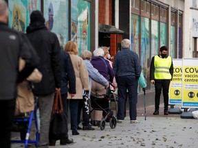 People queue to receive the coronavirus disease (COVID-19) vaccine outside a closed down Debenhams store that is being used as a vaccination centre in Folkestone, Kent, Britain January 28, 2021.