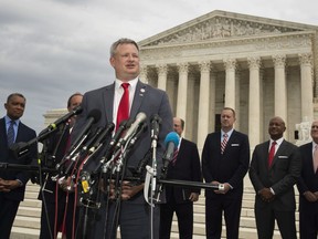South Dakota Attorney General Jason Ravnsborg with a group of state attorneys general speaks to reporters in front of the U.S. Supreme Court in Washington, Monday, Sept. 9, 2019.