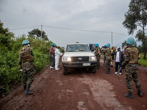 UN peacekeepers and Congolese armed forces stand near an ambulance transporting a victim from the site where Italian Ambassador Luca Attanasio was fatally attacked when the convoy he was traveling in came under attack on February 22, 2021 near the village of Kibumba, Democratic Republic of Congo.