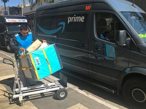 An Amazon worker loads a trolley from a Prime delivery van in Los Angeles, California, U.S. February 25, 2019.