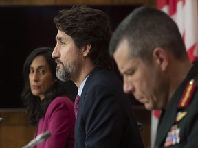 Public Services and Procurement Minister Anita Anand and Major General Dany Fortin look on as Prime Minister Justin Trudeau responds to a question during a news conference in Ottawa, Monday, Dec. 7, 2020.